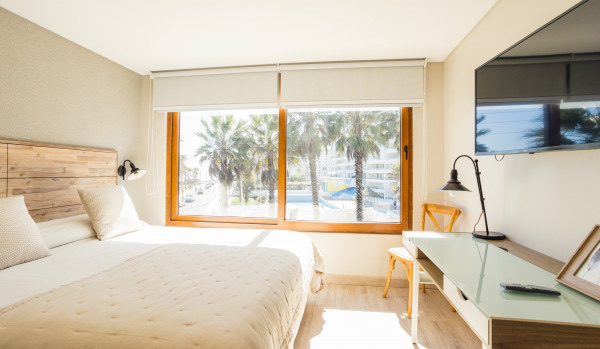 Dormitorio con cama queen y ventanal hacia el mar