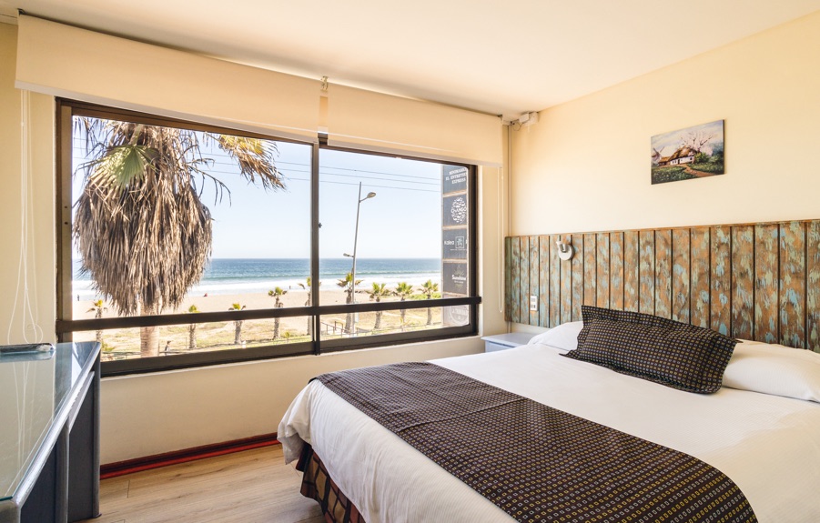 Habitación con cama king y ventanal con vista al mar